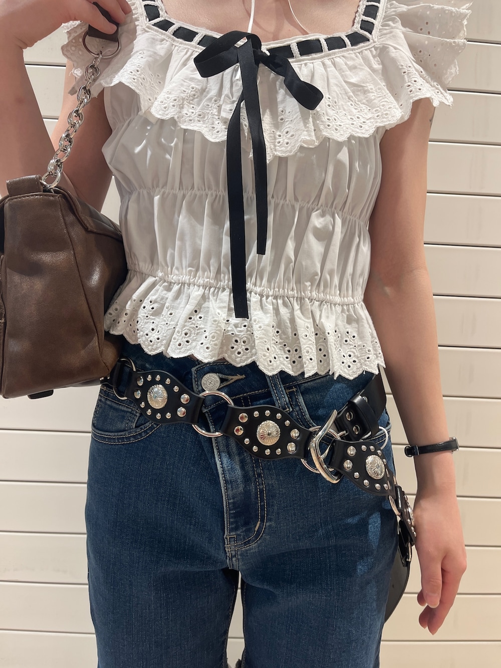 ホワイト系のシャツ/ブラウス、ブルー系のデニムパンツ、ブラウン系のハンドバッグを着用したレディースの春コーディネートの7枚目の写真