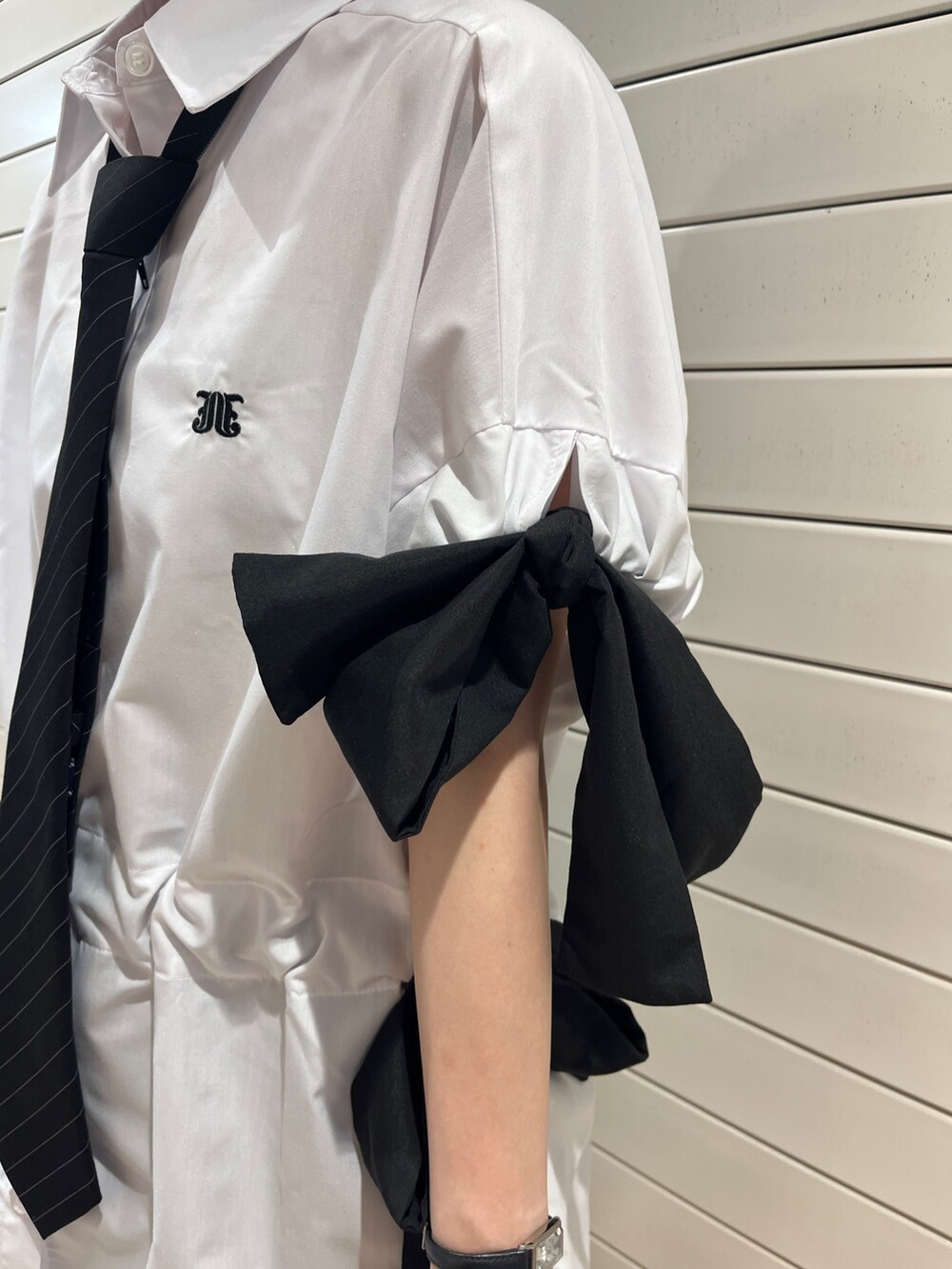 ブラック系のネクタイ、ブラック系のブーツ、ホワイト系のシャツ/ブラウスを着用したレディースの夏コーディネートの7枚目の写真