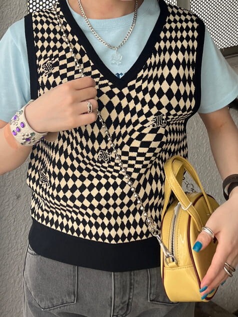 ブラック系のデニムパンツ、ブラック系のニット/セーター、イエロー系のボストンバッグを着用したレディースの夏コーディネートの7枚目の写真