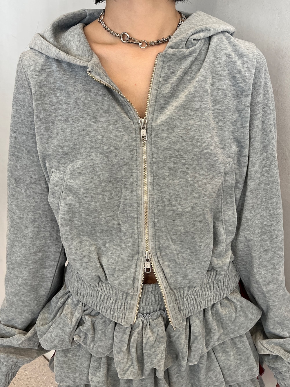 グレー系のパーカー、グレー系のスカート、ブルー系のブーツを着用したレディースの夏コーディネートの8枚目の写真