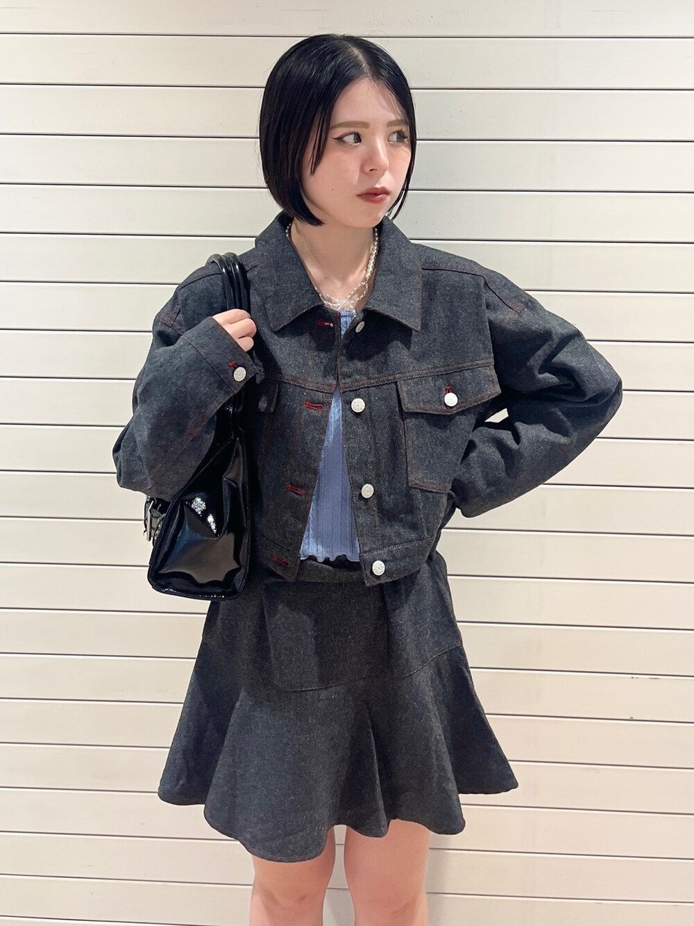 グレー系のワンピース、ブルー系のニット/セーター、ブラック系のハンドバッグを着用したレディースの秋コーディネートの6枚目の写真