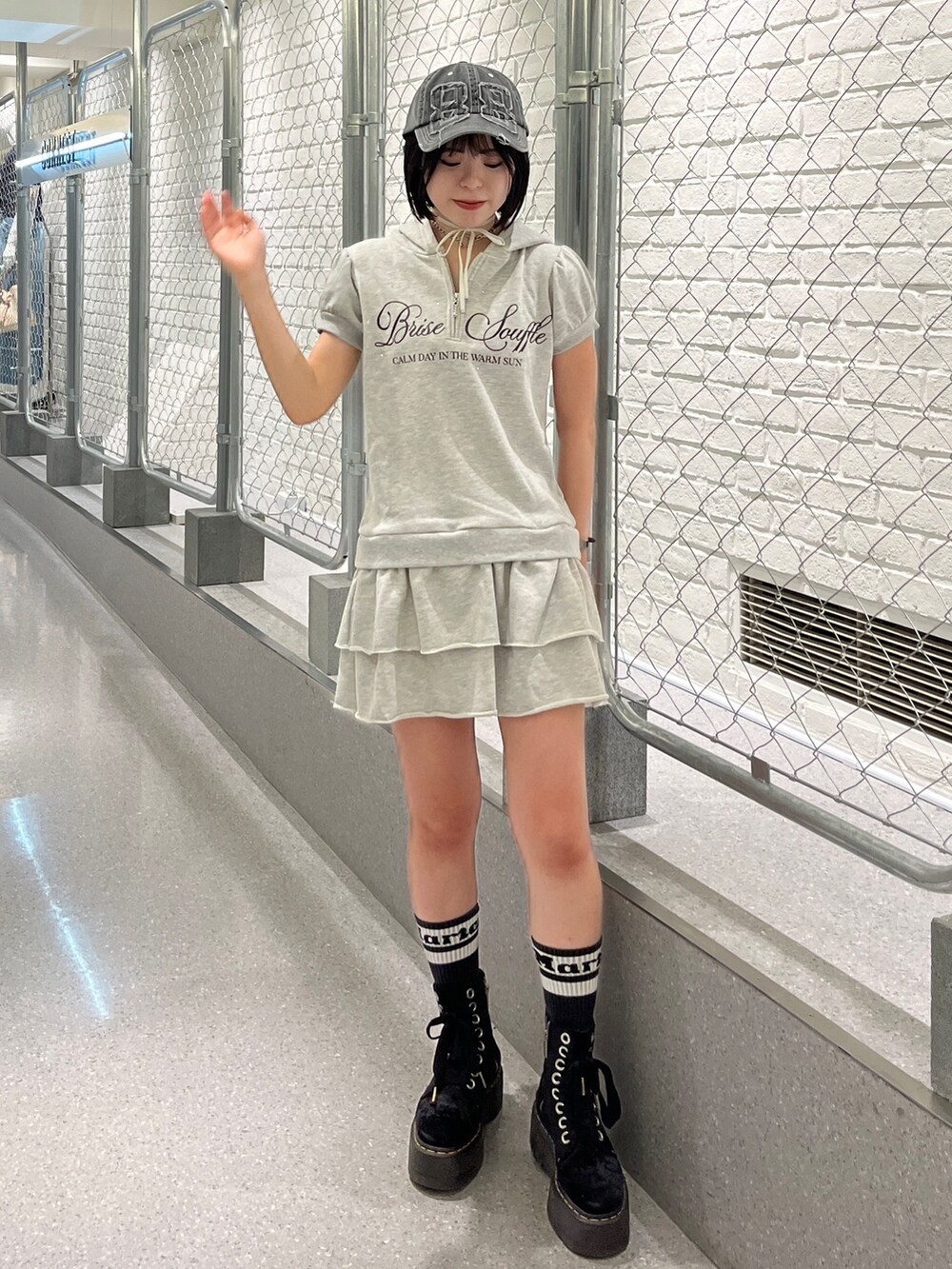 グレー系のワンピース、ブラック系のキャップ、ブラック系のチョーカーを着用したレディースの夏コーディネートの2枚目の写真