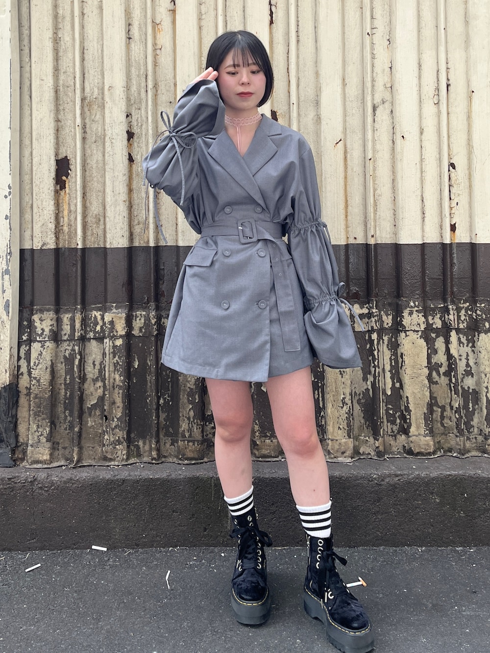 グレー系のテーラードジャケット、ピンク系のチョーカーを着用したレディースの春コーディネートの2枚目の写真