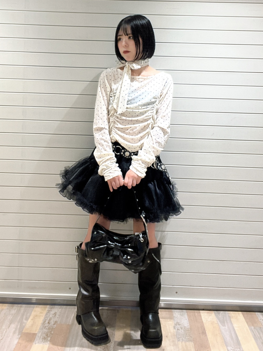 ホワイト系のTシャツ/カットソー、ブラック系のブーツ、ブラック系のスカートを着用したレディースの秋コーディネートの2枚目の写真