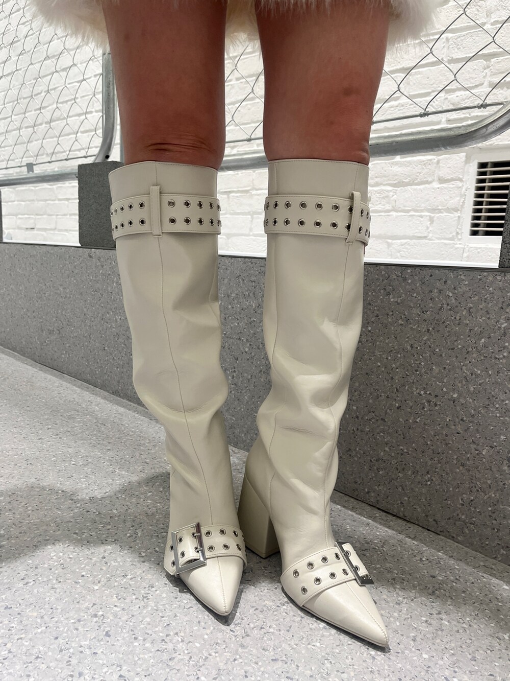 ホワイト系のワンピース、ホワイト系のブーツを着用したレディースの冬コーディネートの9枚目の写真