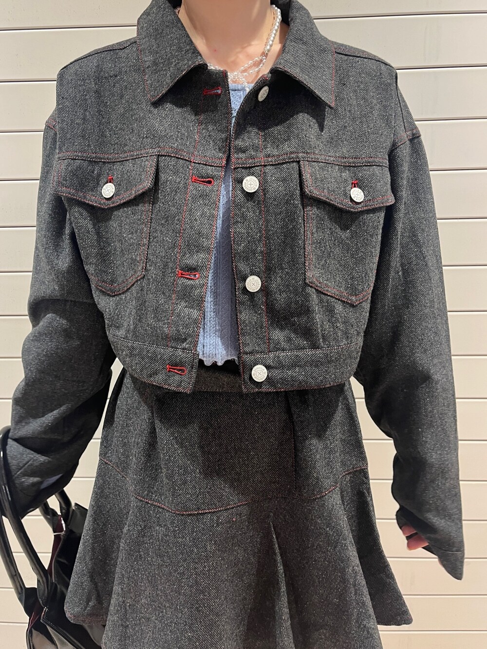 グレー系のワンピース、ブルー系のニット/セーター、ブラック系のハンドバッグを着用したレディースの秋コーディネートの8枚目の写真