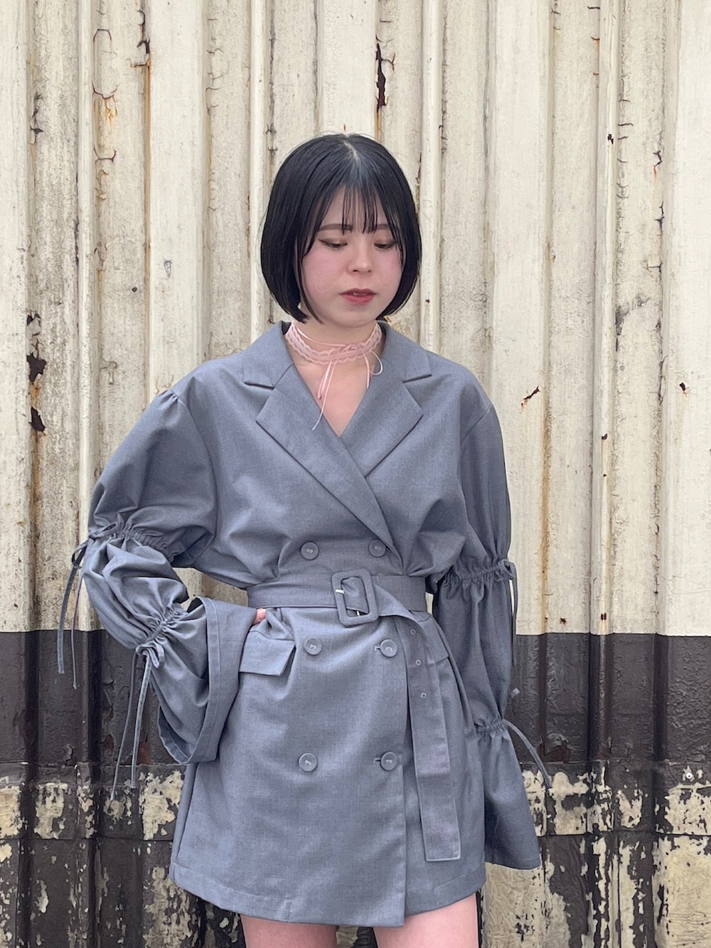 グレー系のテーラードジャケット、ピンク系のチョーカーを着用したレディースの春コーディネートの5枚目の写真
