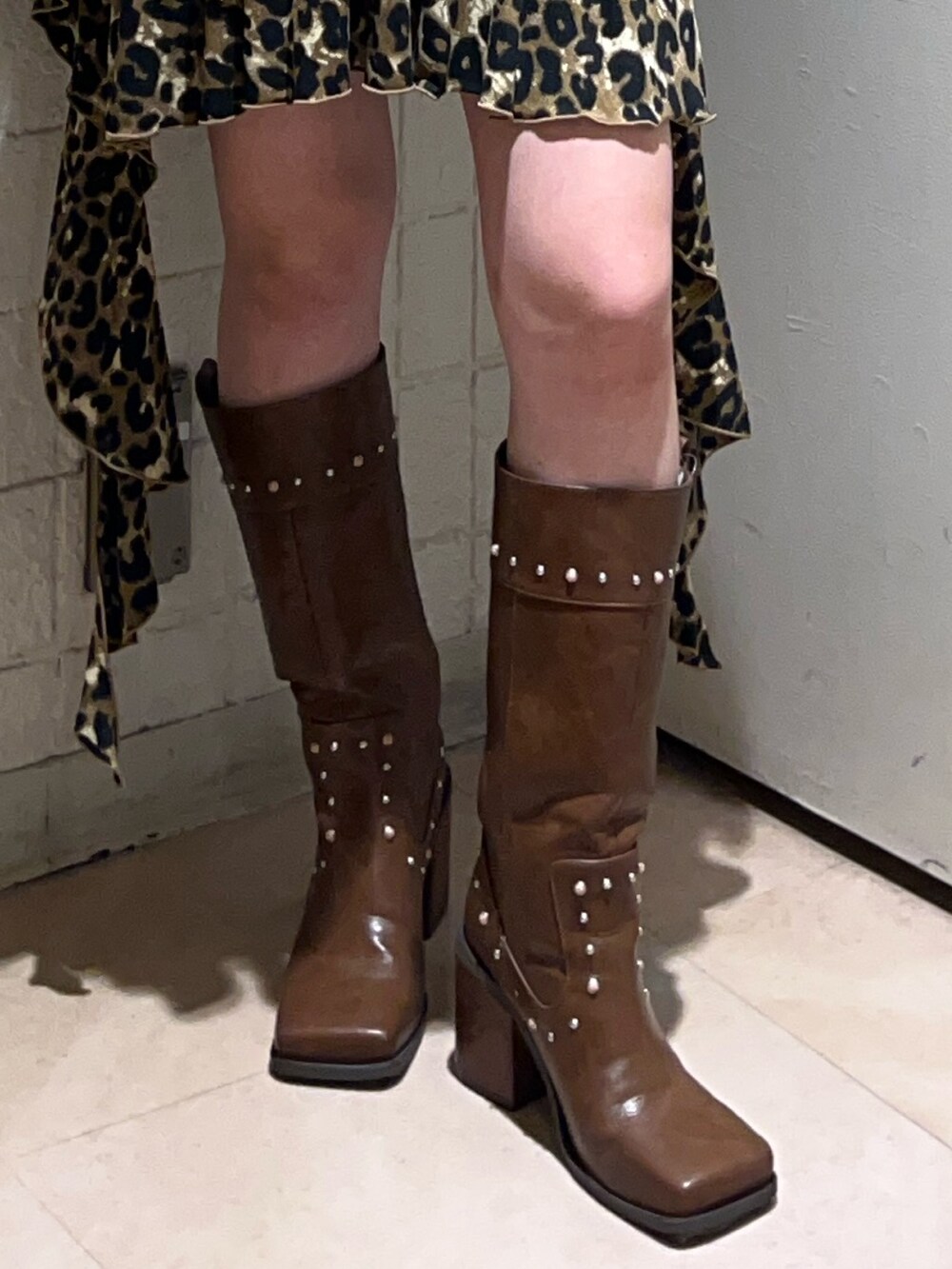 ブラウン系のワンピース、ホワイト系のTシャツ/カットソー、ブラウン系のブーツを着用したレディースの夏コーディネートの7枚目の写真