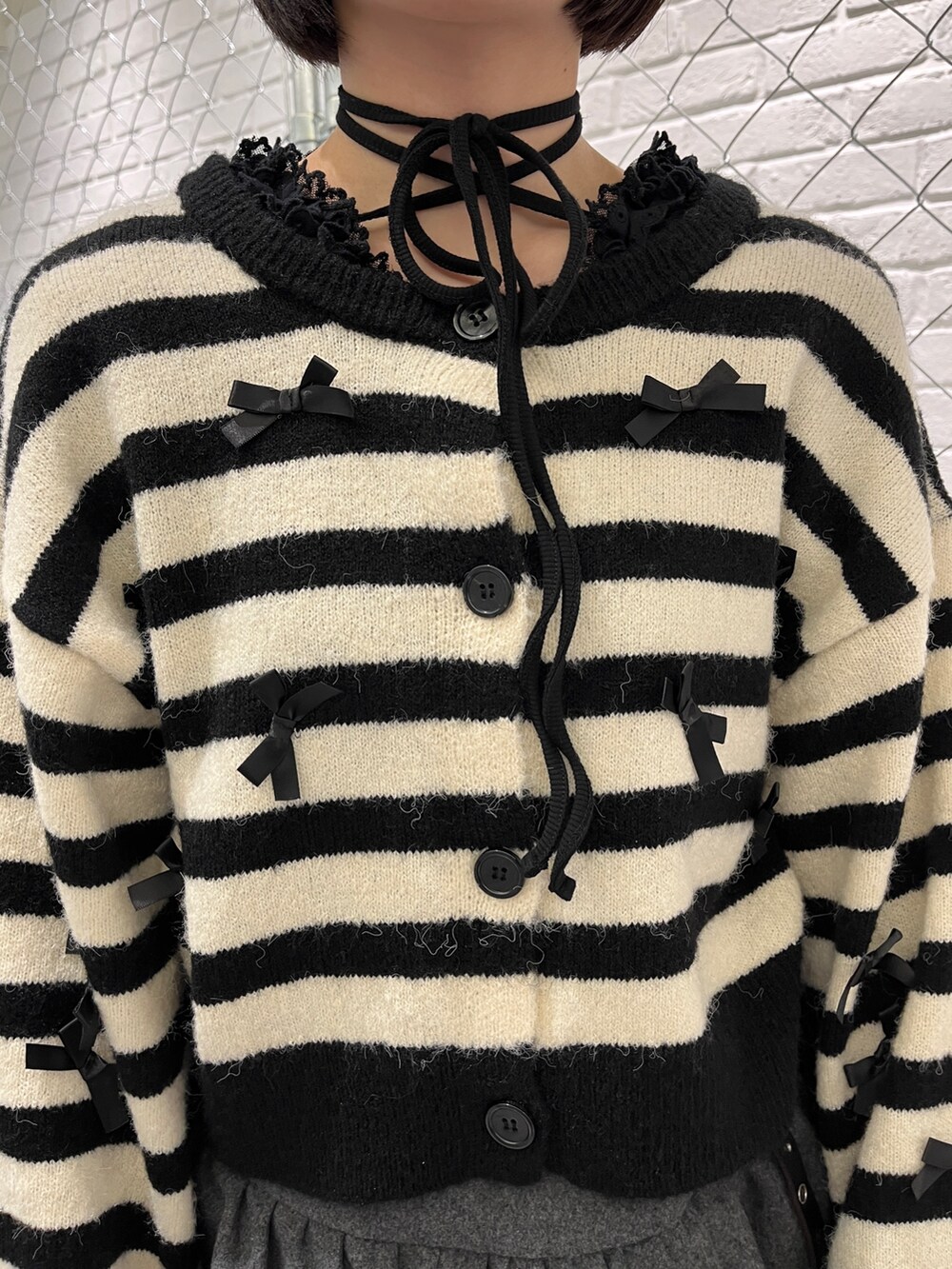 その他のカーディガン/ボレロ、ブラック系のTシャツ/カットソー、グレー系のスカートを着用したレディースの冬コーディネートの7枚目の写真