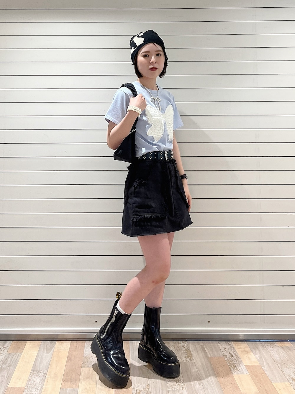 ブラック系のショルダーバッグ、ブラック系のスカート、ブルー系のTシャツ/カットソーを着用したレディースの春コーディネートの3枚目の写真