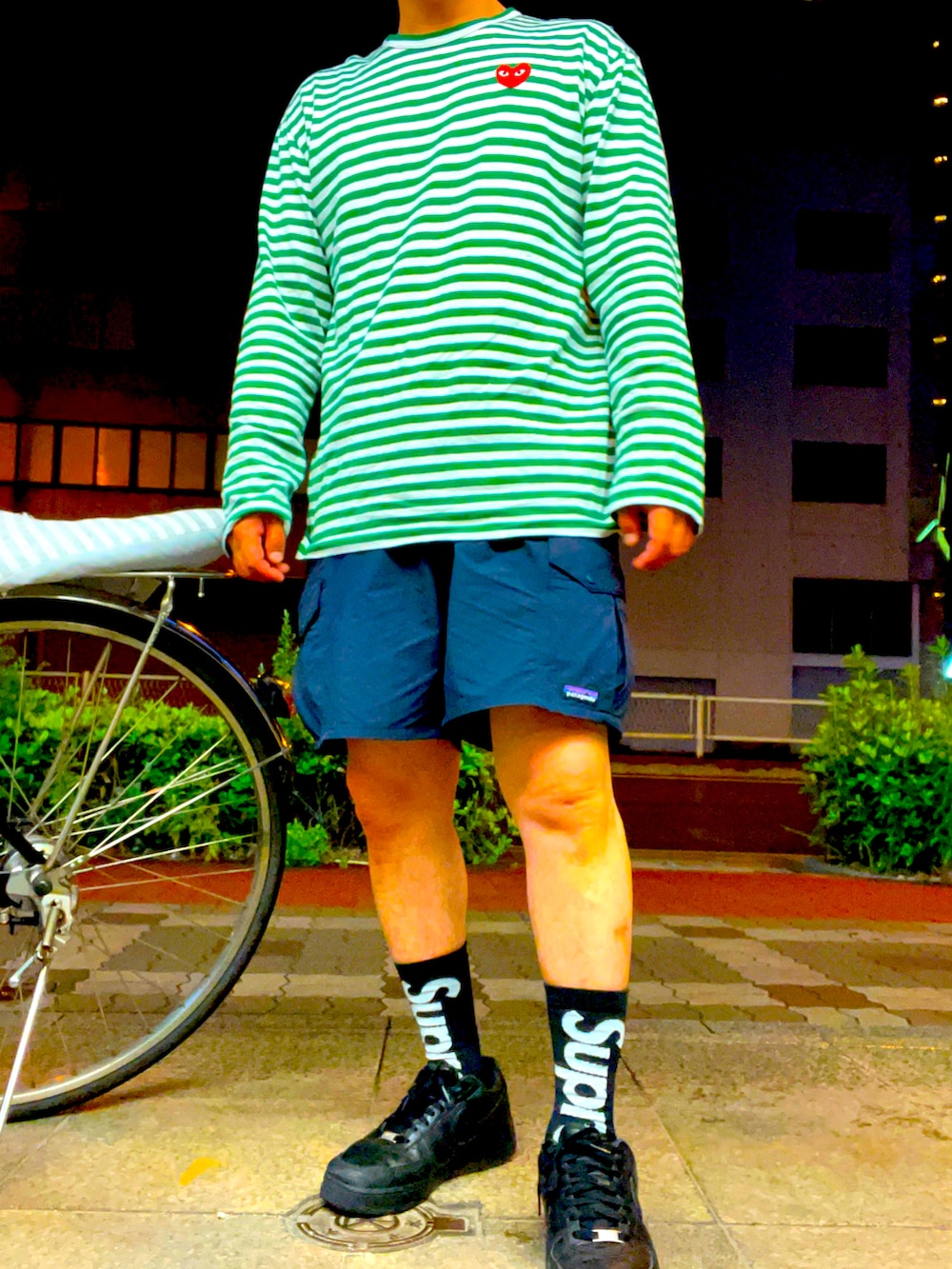 ブラック系のその他パンツ、グリーン系のTシャツ/カットソー、ブラック系のスニーカーを着用したメンズの春コーディネートの2枚目の写真