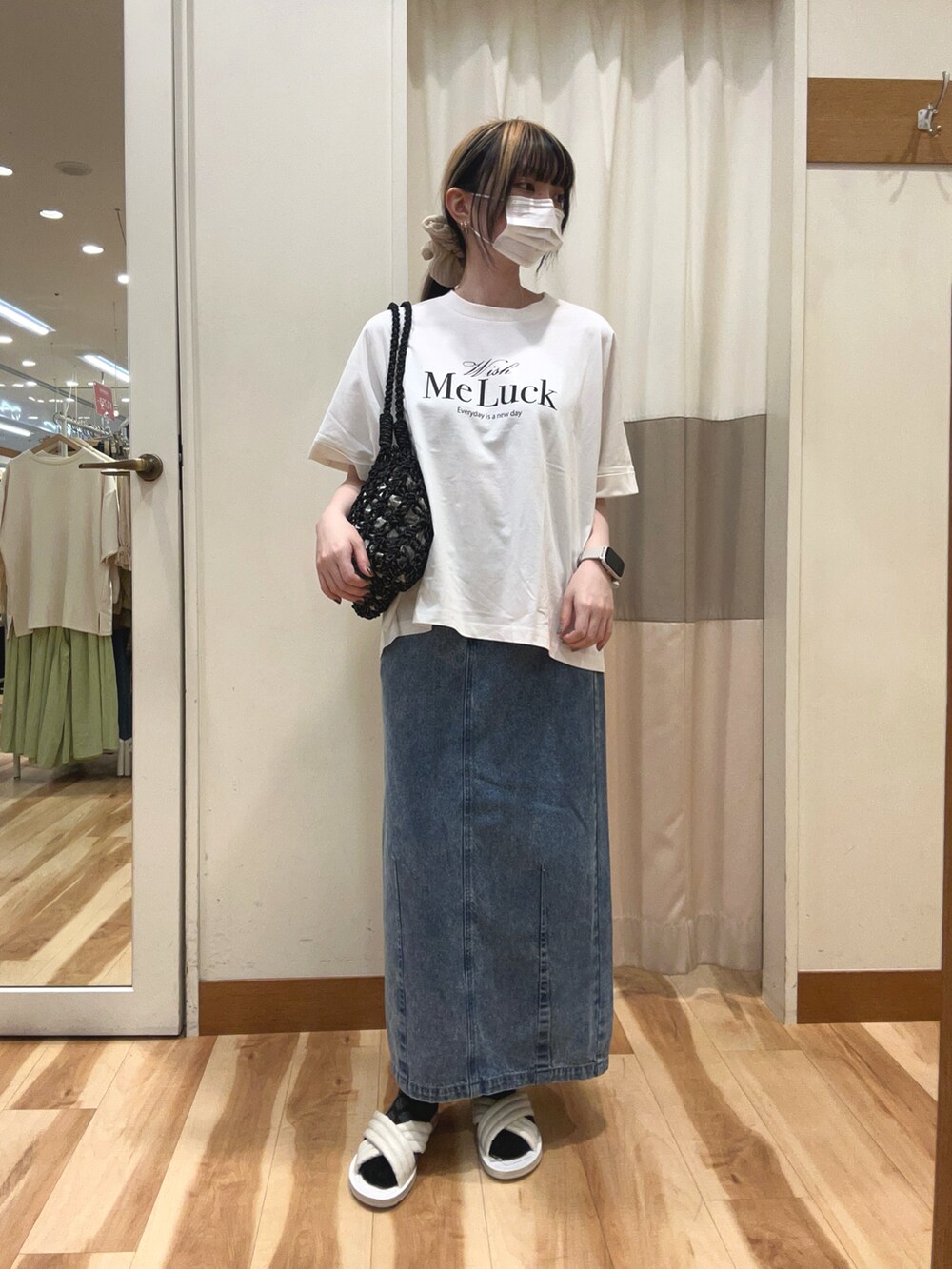 ブラック系のシャツ/ブラウス、ブラック系のハンドバッグ、ブルー系のデニムスカートを着用したレディースの春コーディネートの3枚目の写真