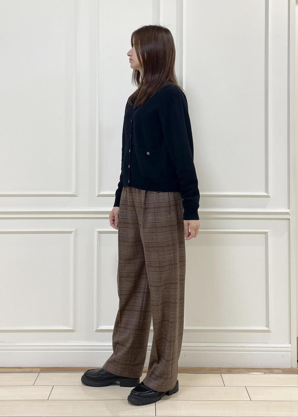 ホワイト系のトートバッグ、ブラック系のカーディガン/ボレロ、ブラウン系のその他パンツを着用したレディースの秋コーディネートの3枚目の写真