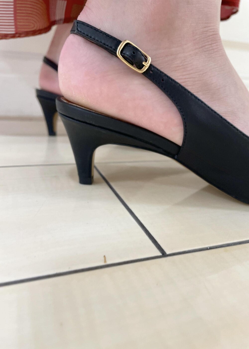 ブラック系のパンプス、レッド系のスカート、ブラック系のTシャツ/カットソーを着用したレディースの夏コーディネートの9枚目の写真