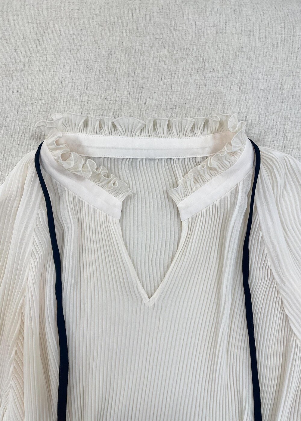 ホワイト系のショルダーバッグ、ブラック系のデニムパンツを着用したレディースの秋コーディネートの5枚目の写真