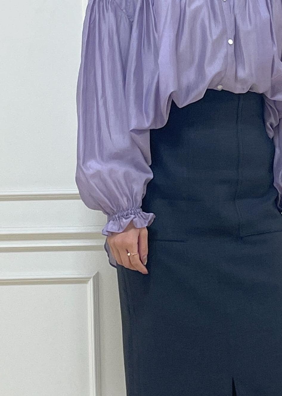 ホワイト系のハンドバッグ、ブラック系のスカート、ホワイト系のサンダルを着用したレディースの春コーディネートの6枚目の写真