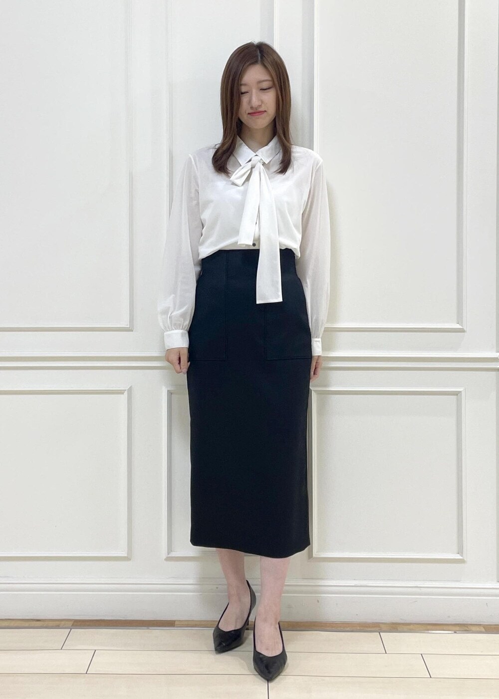 ベージュ系のトートバッグ、ブラック系のスカート、ホワイト系のシャツ/ブラウスを着用したレディースの秋コーディネートの5枚目の写真