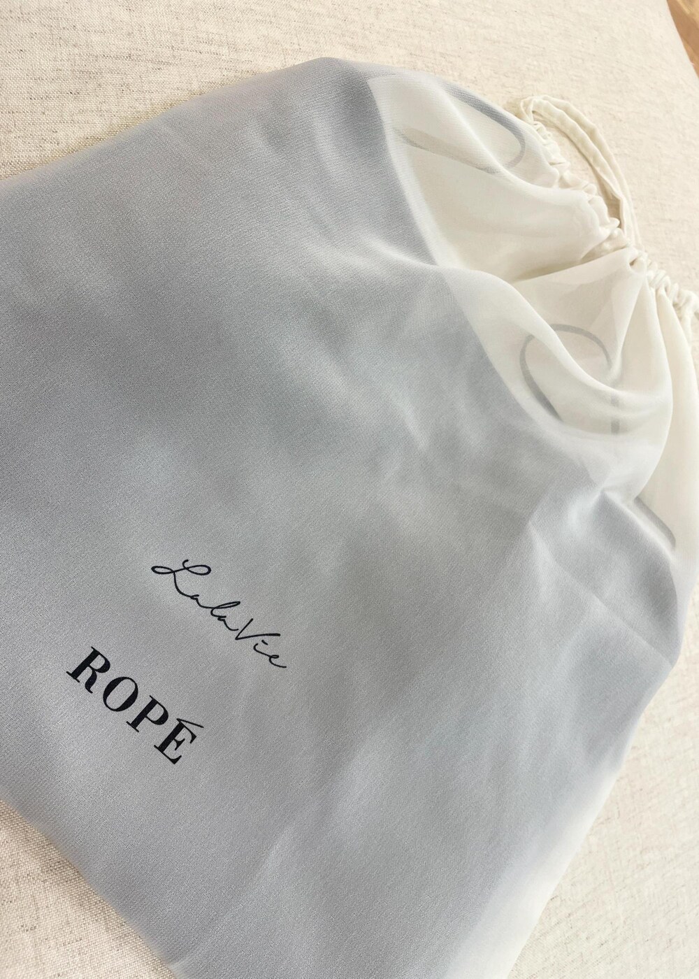 グリーン系のハンドバッグ、ホワイト系のスカート、ブラック系のキャミソールを着用したレディースの夏コーディネートの6枚目の写真