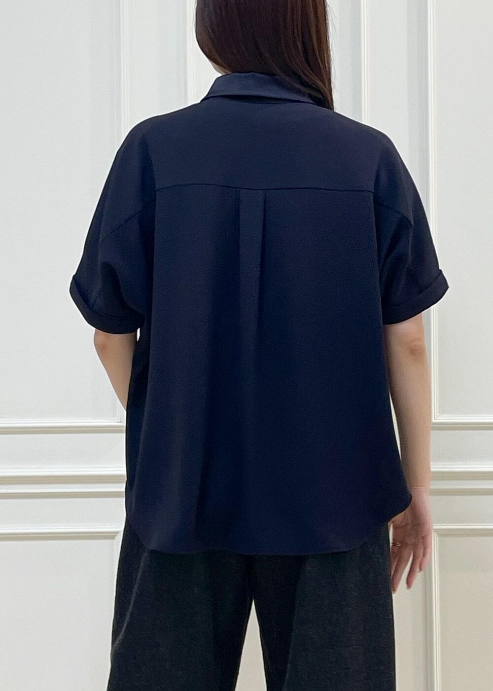 ブラック系のデニムパンツ、ベージュ系のショルダーバッグ、ブルー系のニット/セーターを着用したレディースの春コーディネートの3枚目の写真