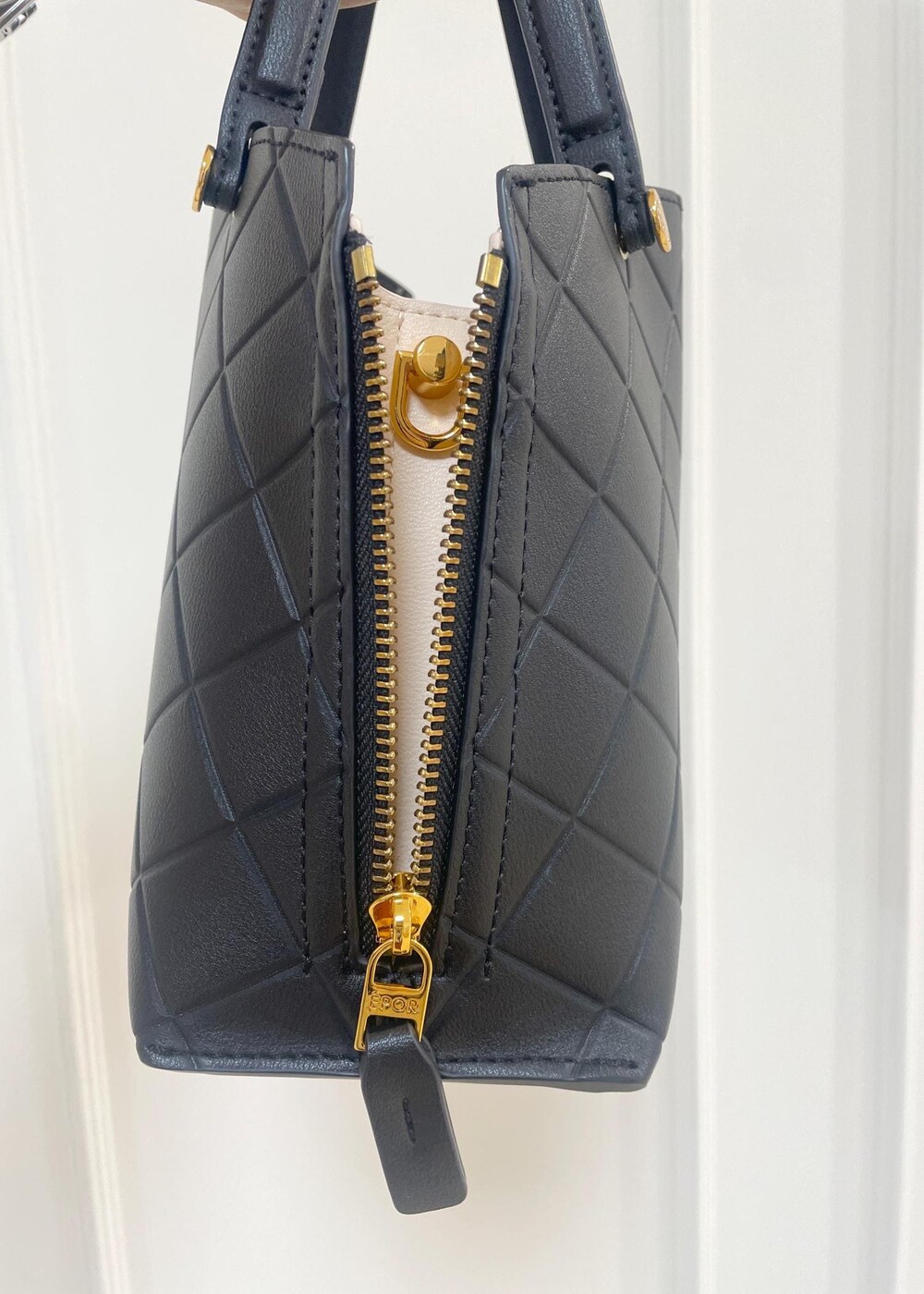 ブラック系のハンドバッグ、レッド系のスカート、ブラック系のシャツ/ブラウスを着用したレディースの夏コーディネートの6枚目の写真