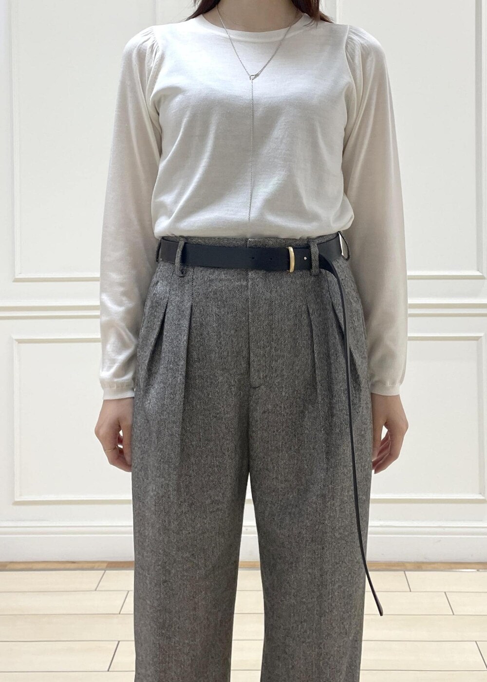 ホワイト系のハンドバッグ、ブラック系のローファー、ホワイト系のニット/セーターを着用したレディースの秋コーディネートの2枚目の写真