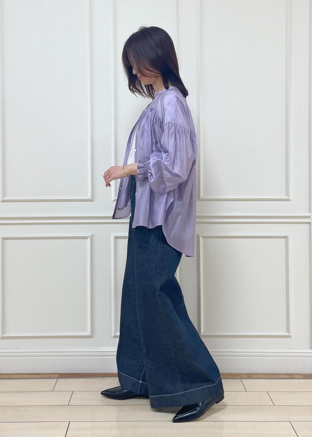 ホワイト系のハンドバッグ、ブラック系のパンプス、ブルー系のデニムパンツを着用したレディースの春コーディネートの2枚目の写真