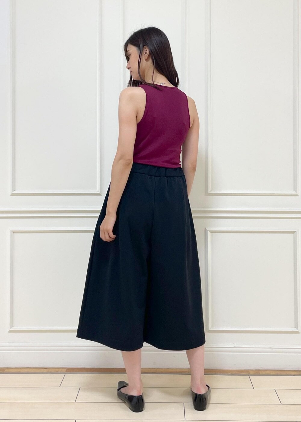 レッド系のタンクトップ、ベージュ系のショルダーバッグ、ブラック系のその他パンツを着用したレディースの夏コーディネートの6枚目の写真