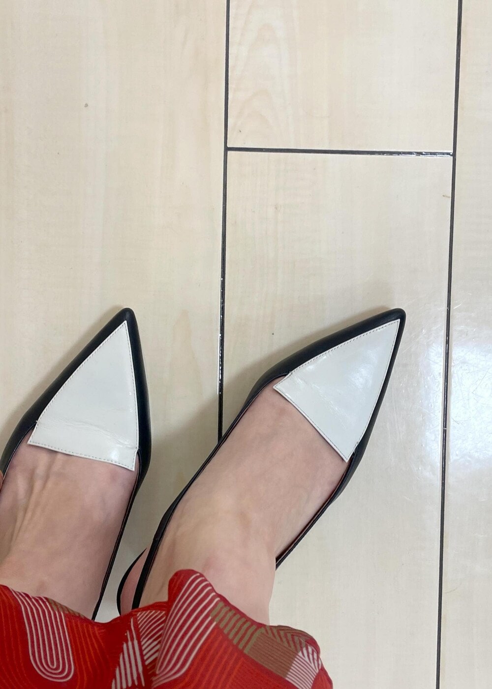 ブラック系のパンプス、レッド系のスカート、ブラック系のTシャツ/カットソーを着用したレディースの夏コーディネートの8枚目の写真