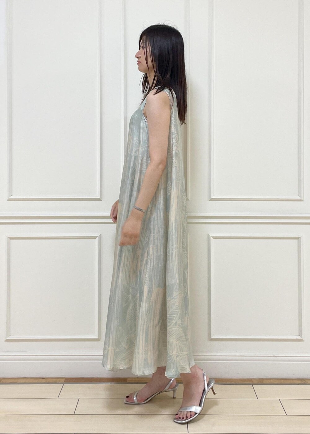 ホワイト系のハンドバッグ、シルバー系のサンダル、グリーン系のワンピースを着用したレディースの夏コーディネートの4枚目の写真