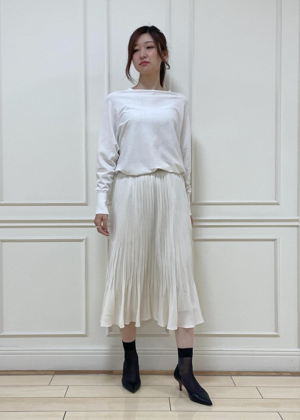 ブラック系のパンプス、ホワイト系のスカート、ブラック系のハンドバッグを着用したレディースの春コーディネートの5枚目の写真