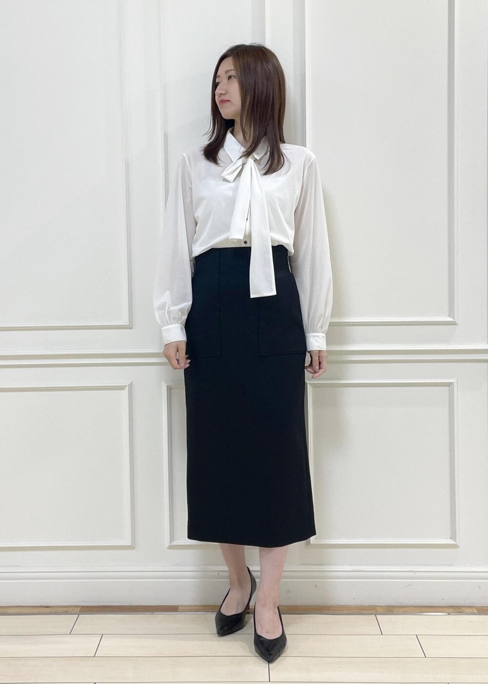 ホワイト系のトートバッグ、ブラック系のスカート、ホワイト系のシャツ/ブラウスを着用したレディースの秋コーディネートの5枚目の写真