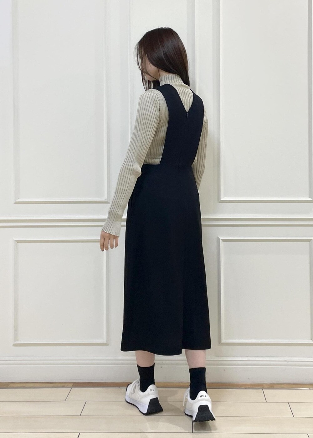 ブラック系のワンピース、ベージュ系のニット/セーター、イエロー系のハンドバッグを着用したレディースの秋コーディネートの4枚目の写真