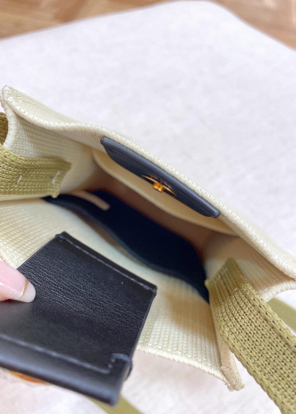 ブラック系のデニムパンツ、ベージュ系のショルダーバッグ、ブルー系のニット/セーターを着用したレディースの春コーディネートの9枚目の写真