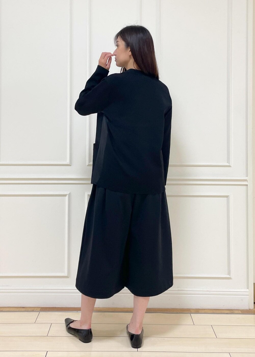 レッド系のタンクトップ、ベージュ系のショルダーバッグ、ブラック系のその他パンツを着用したレディースの夏コーディネートの3枚目の写真