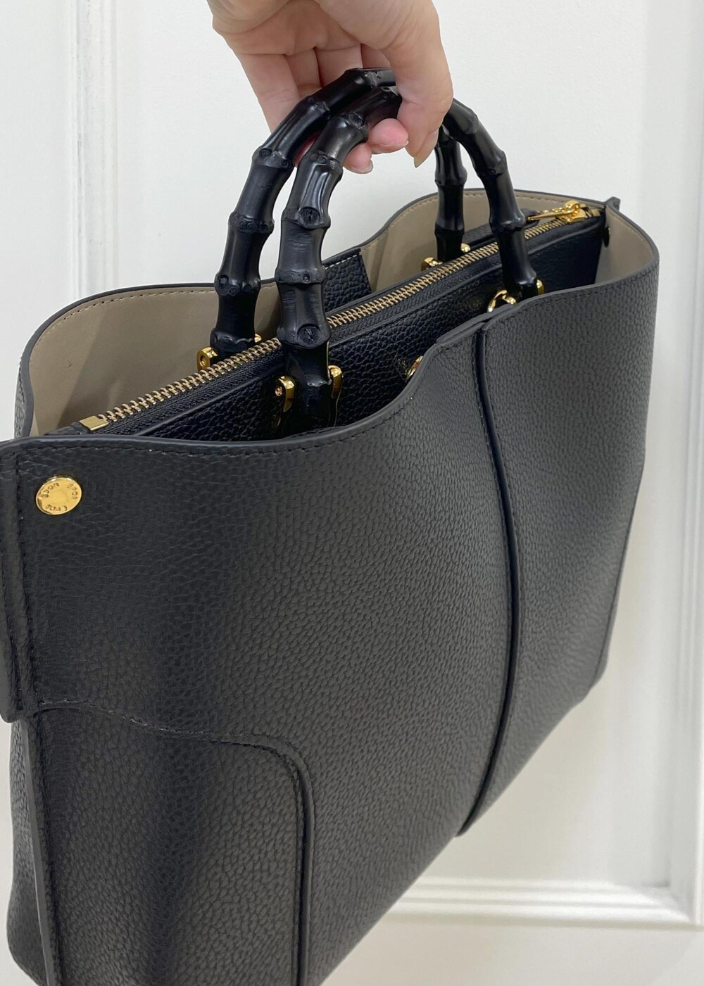 ブラック系のハンドバッグ、ホワイト系のカーディガン/ボレロ、ホワイト系のニット/セーターを着用したレディースの秋コーディネートの10枚目の写真