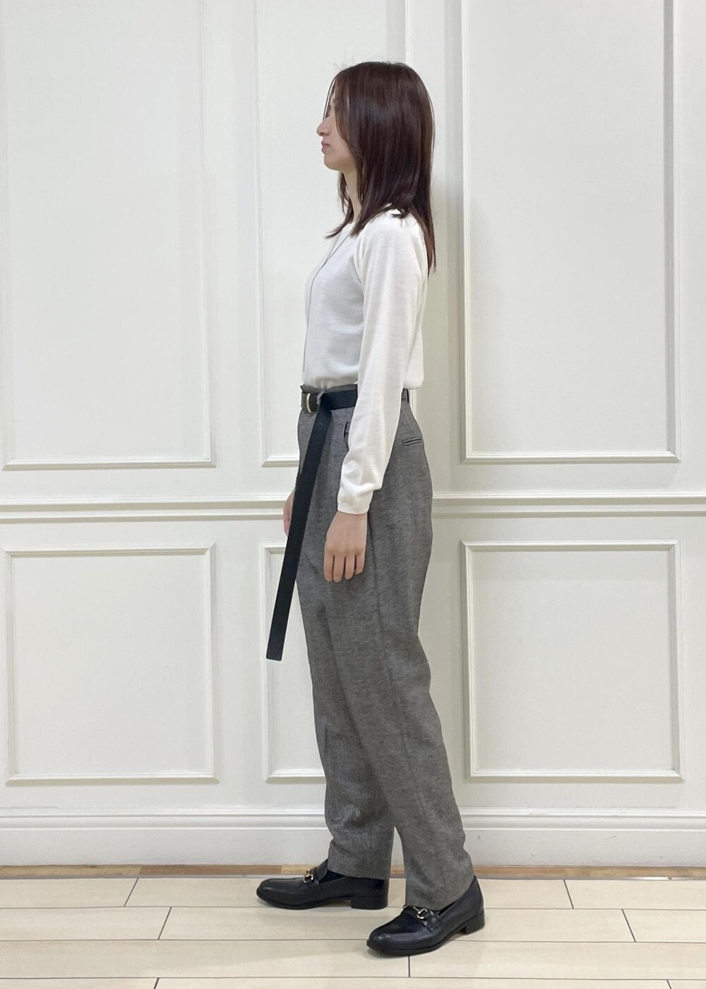 ホワイト系のハンドバッグ、ブラック系のローファー、ホワイト系のニット/セーターを着用したレディースの秋コーディネートの3枚目の写真