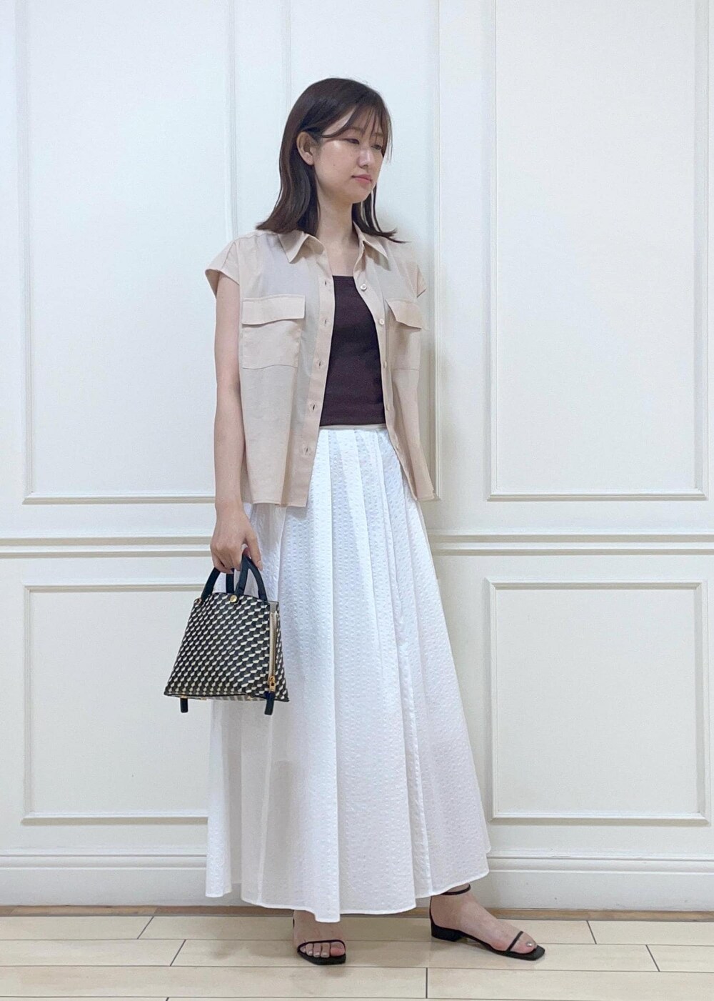 ピンク系のシャツ/ブラウス、ブラック系のショルダーバッグ、ブラック系のサンダルを着用したレディースの夏コーディネートの2枚目の写真