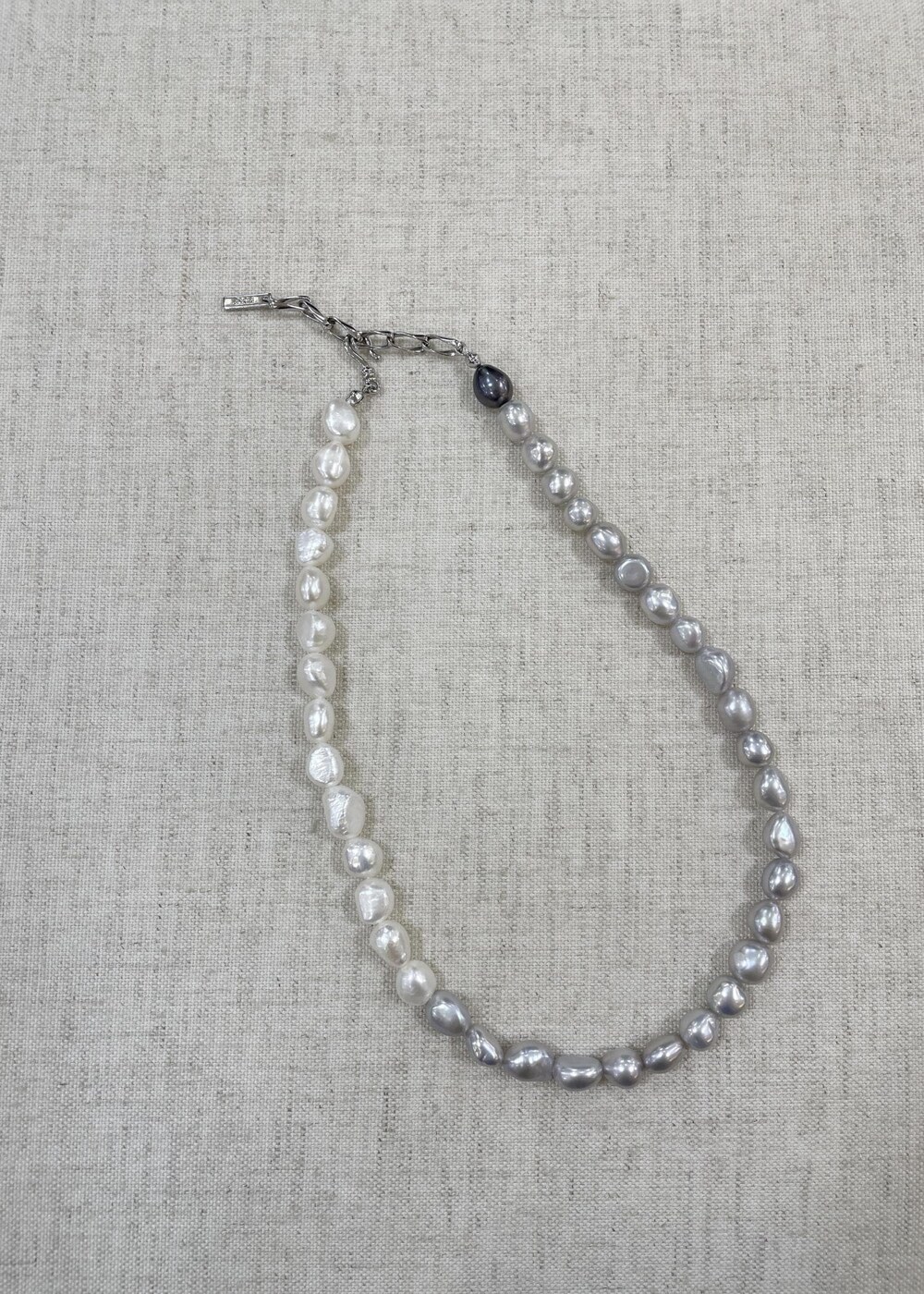 グレー系のハンドバッグ、ブラウン系のスカート、ブラック系のニット/セーターを着用したレディースの秋コーディネートの8枚目の写真