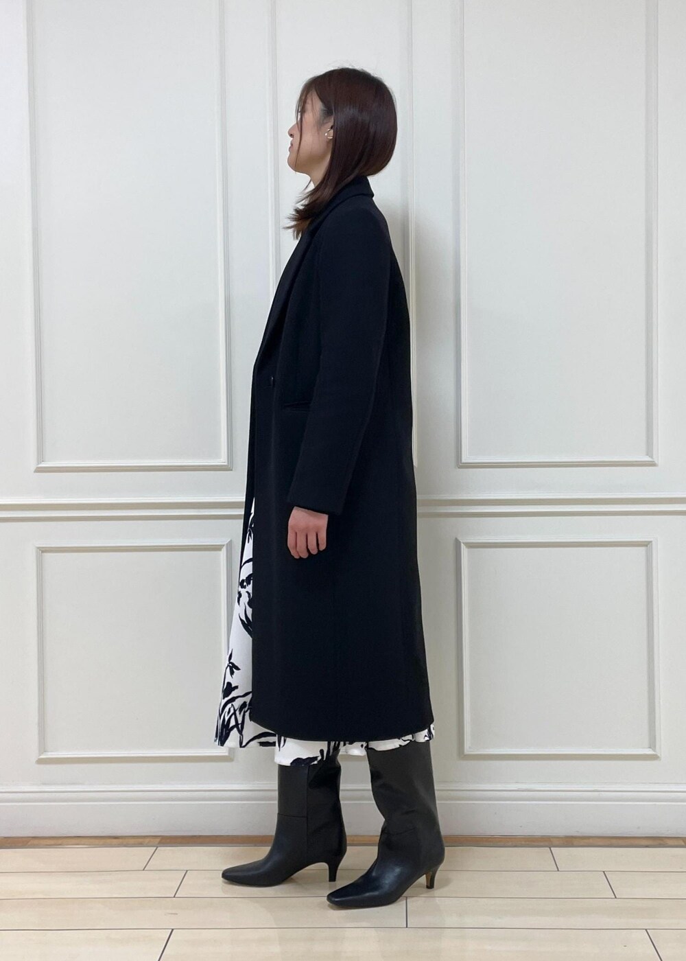 ブルー系のハンドバッグ、ブラック系のブーツ、ブラック系のチェスターコートを着用したレディースの冬コーディネートの2枚目の写真