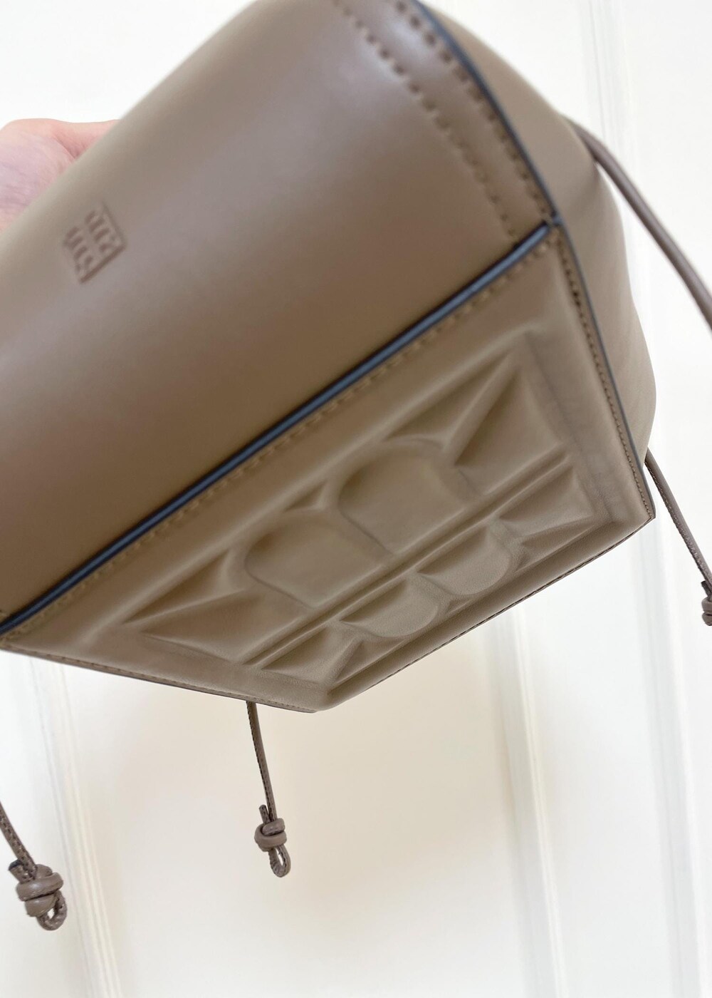 ベージュ系のハンドバッグ、ブラック系のブーツ、レッド系のシャツ/ブラウスを着用したレディースの秋コーディネートの9枚目の写真