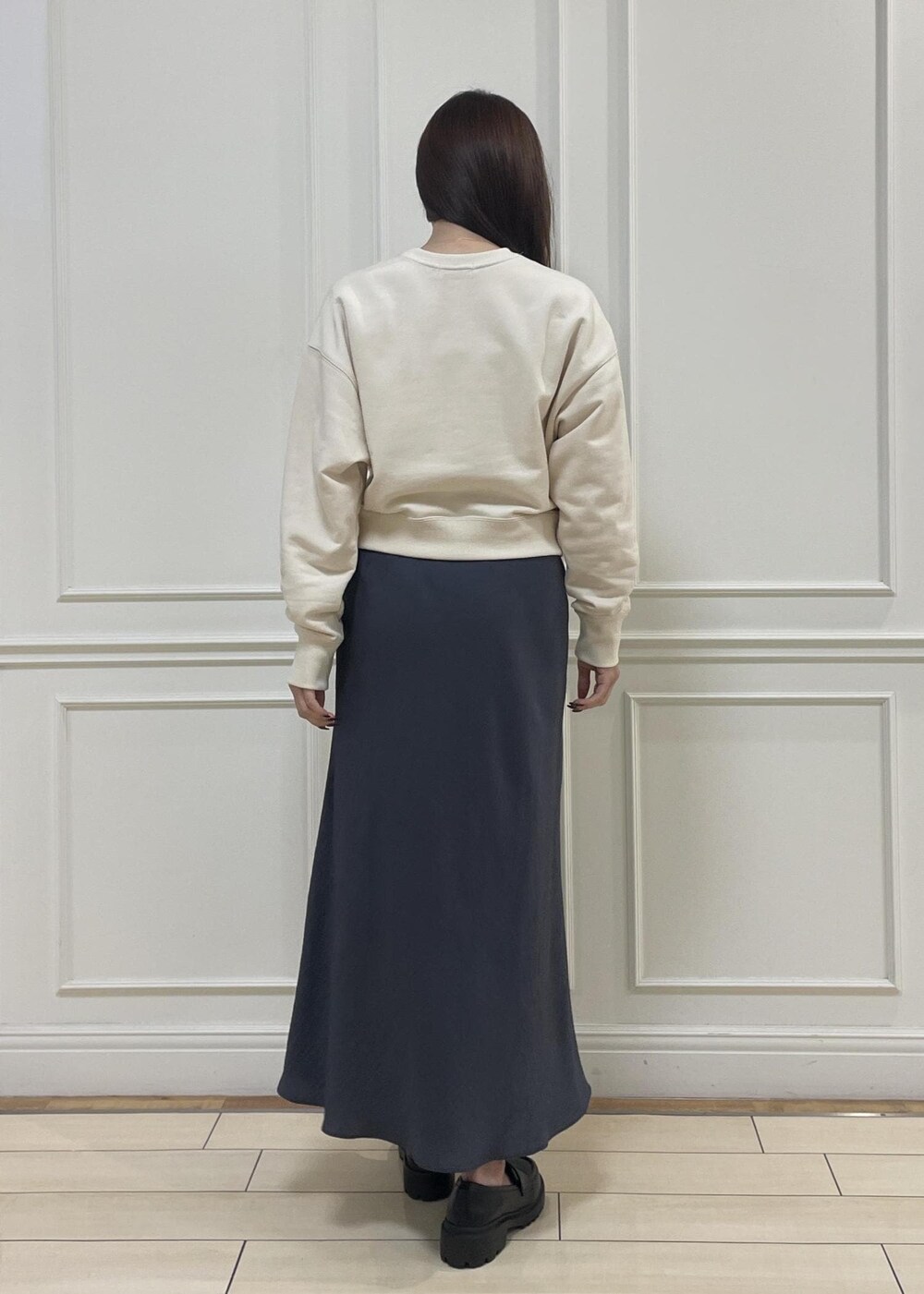 ブルー系のトートバッグ、グレー系のスカート、ベージュ系のスウェットを着用したレディースの秋コーディネートの5枚目の写真