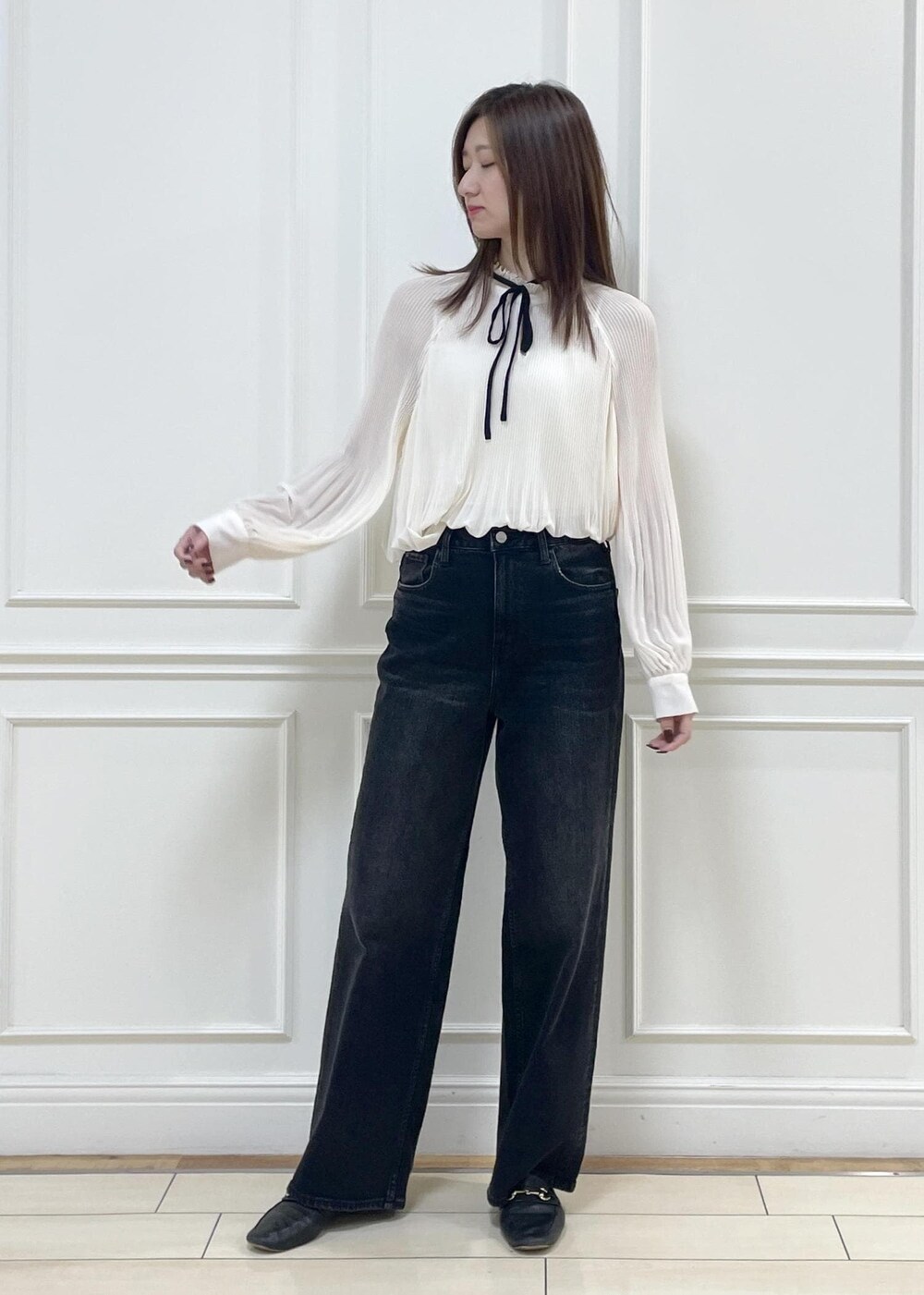 ホワイト系のショルダーバッグ、ブラック系のデニムパンツを着用したレディースの秋コーディネートの9枚目の写真