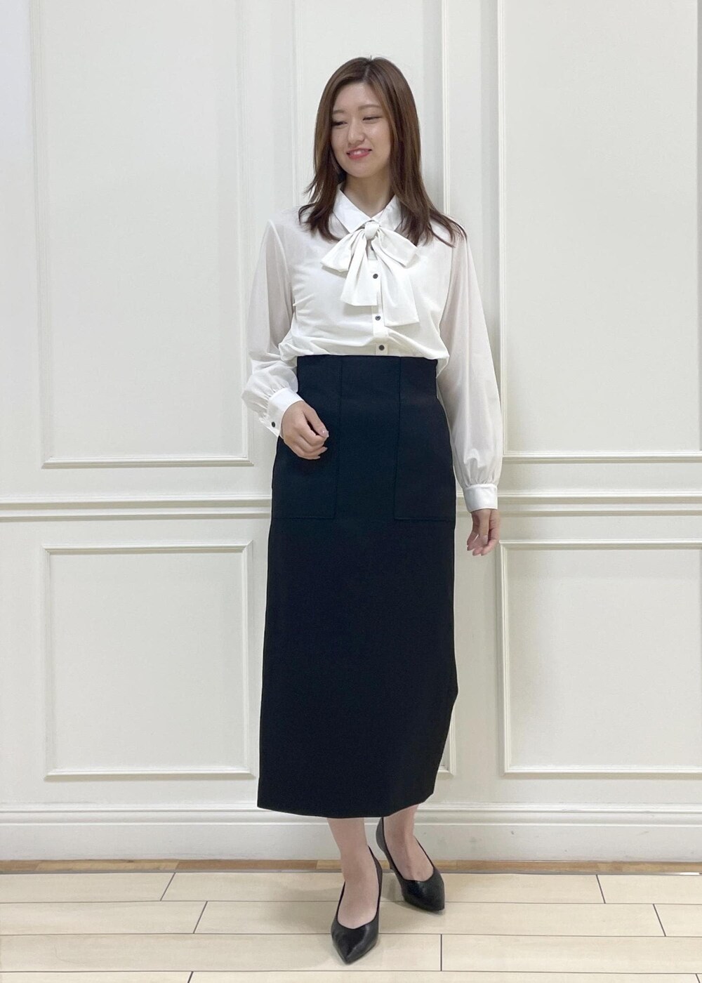 ホワイト系のトートバッグ、ブラック系のスカート、ホワイト系のシャツ/ブラウスを着用したレディースの秋コーディネートの3枚目の写真