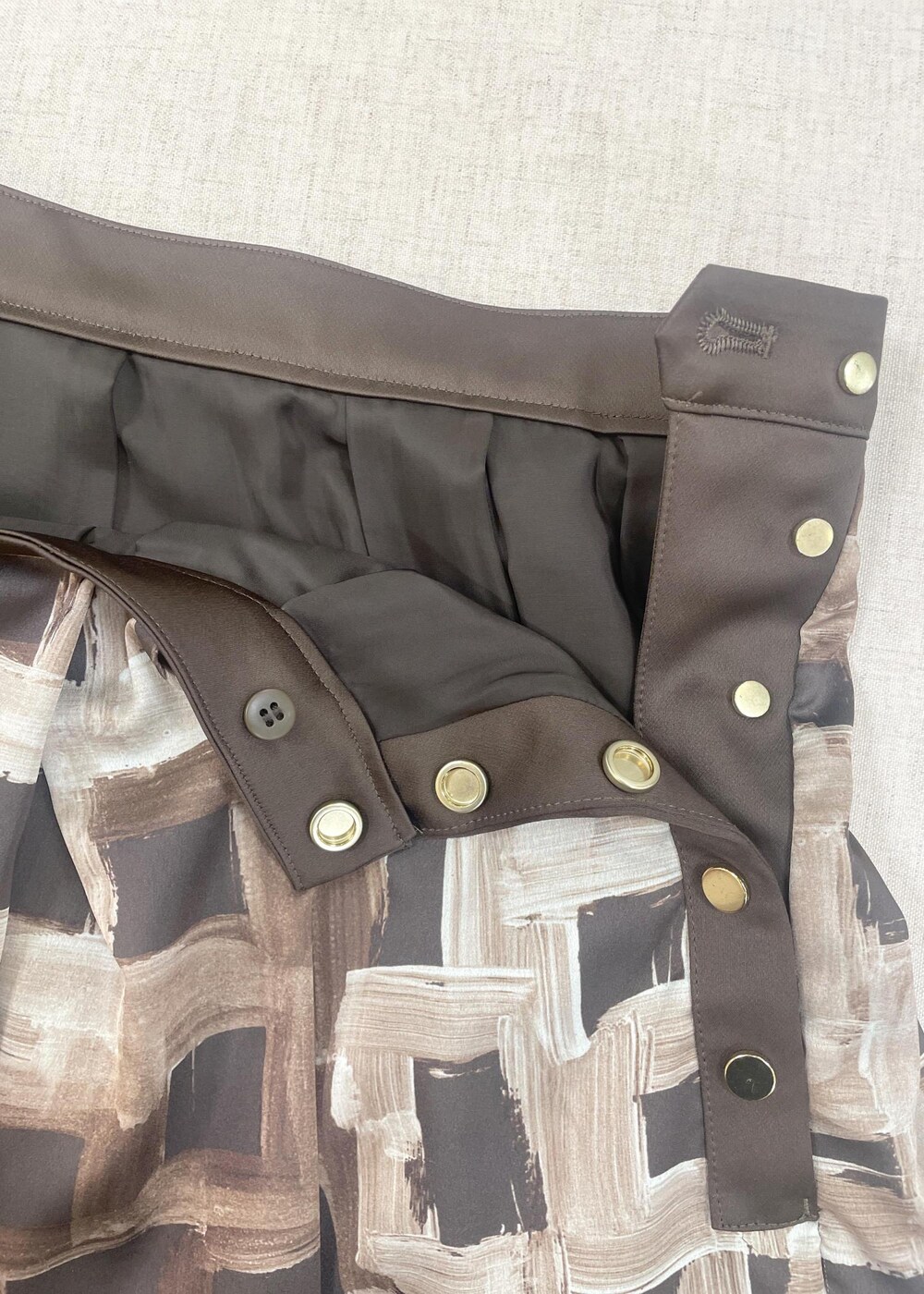 グレー系のハンドバッグ、ブラウン系のスカート、ブラック系のニット/セーターを着用したレディースの秋コーディネートの6枚目の写真