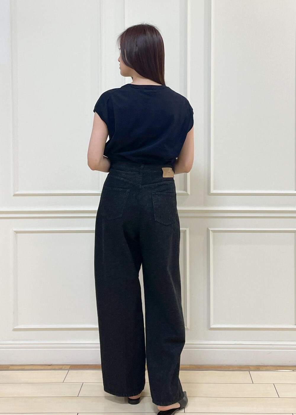 ブラック系のデニムパンツ、ベージュ系のショルダーバッグ、ブルー系のニット/セーターを着用したレディースの春コーディネートの6枚目の写真