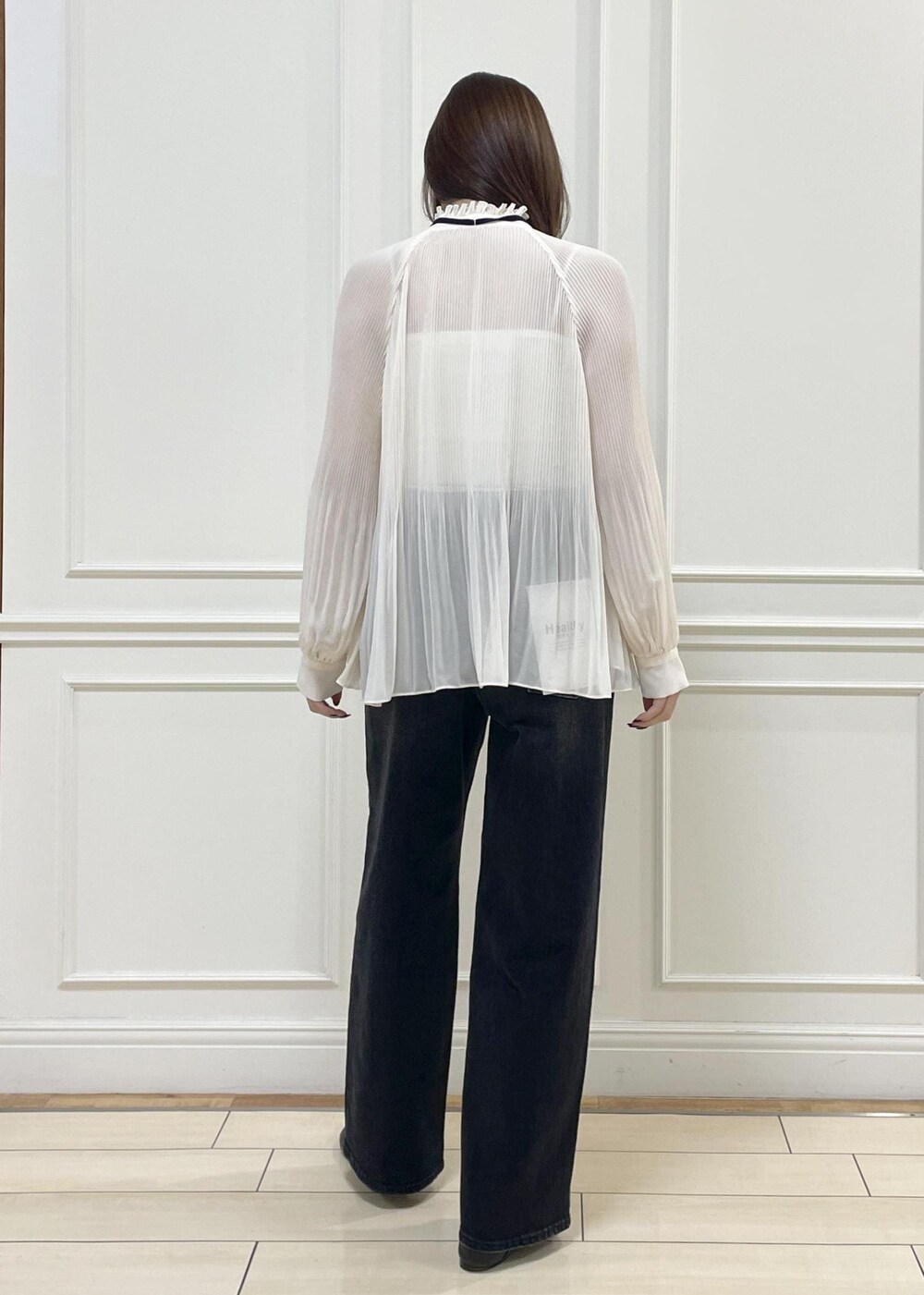 ホワイト系のショルダーバッグ、ブラック系のデニムパンツを着用したレディースの秋コーディネートの4枚目の写真