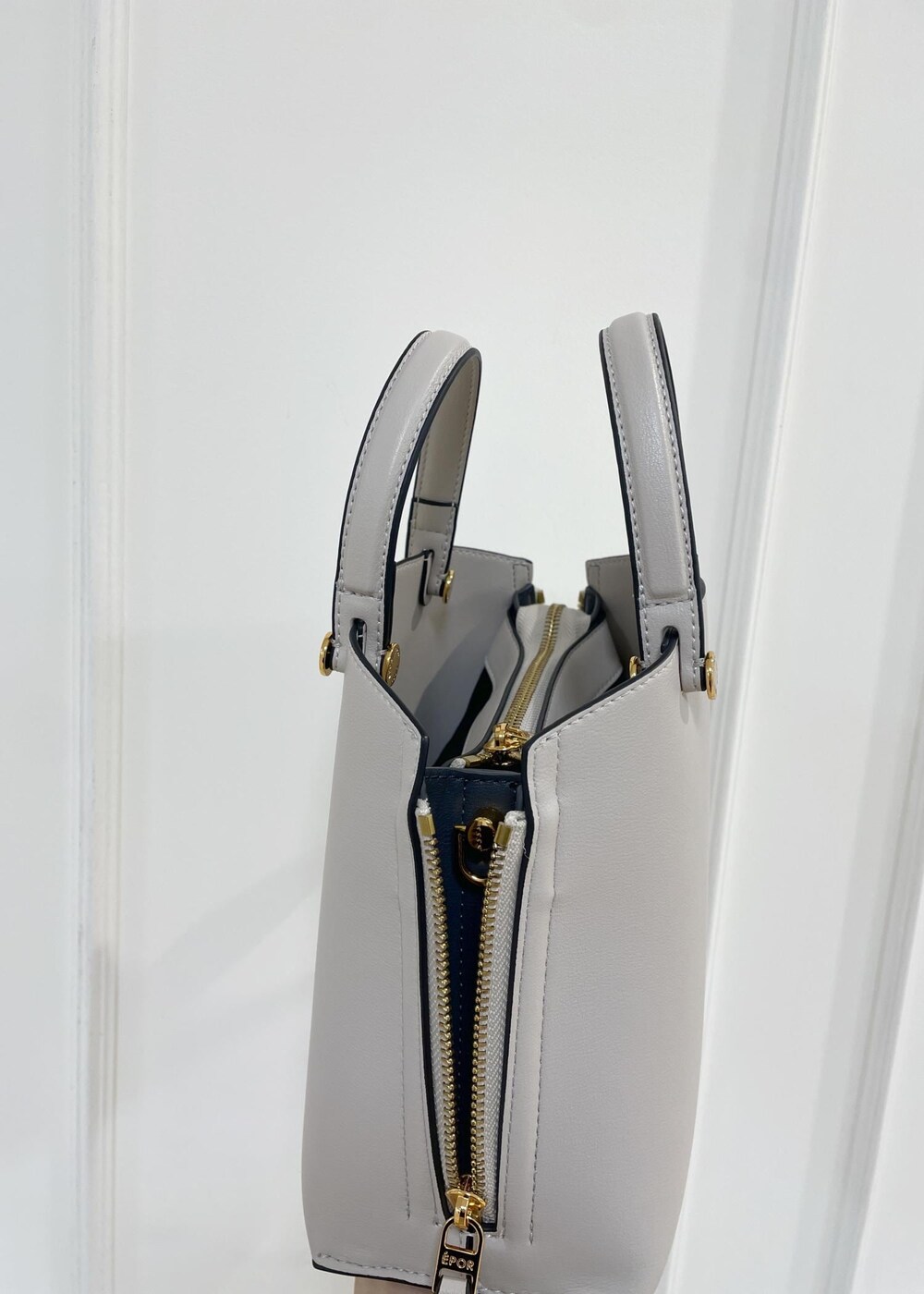 グレー系のハンドバッグ、ブラウン系のスカート、ブラック系のニット/セーターを着用したレディースの秋コーディネートの7枚目の写真