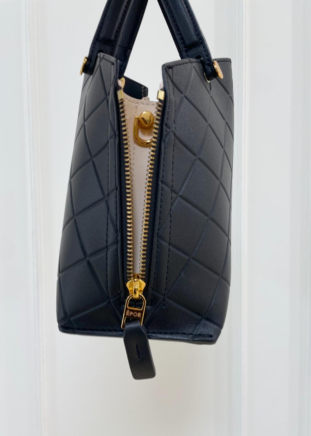 ブラック系のハンドバッグ、ベージュ系のスカート、ブルー系のシャツ/ブラウスを着用したレディースの夏コーディネートの5枚目の写真