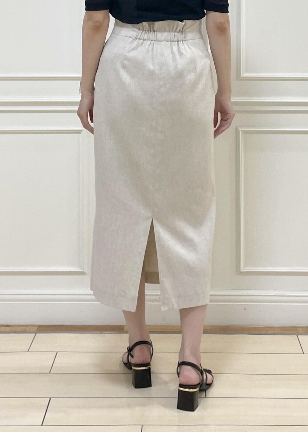 グリーン系のハンドバッグ、ホワイト系のスカート、ブラック系のキャミソールを着用したレディースの夏コーディネートの5枚目の写真