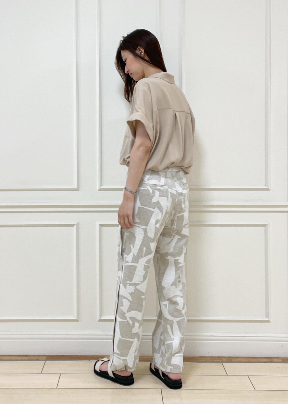 ブラック系のショルダーバッグ、ホワイト系のサンダル、ベージュ系のシャツ/ブラウスを着用したレディースの春コーディネートの4枚目の写真